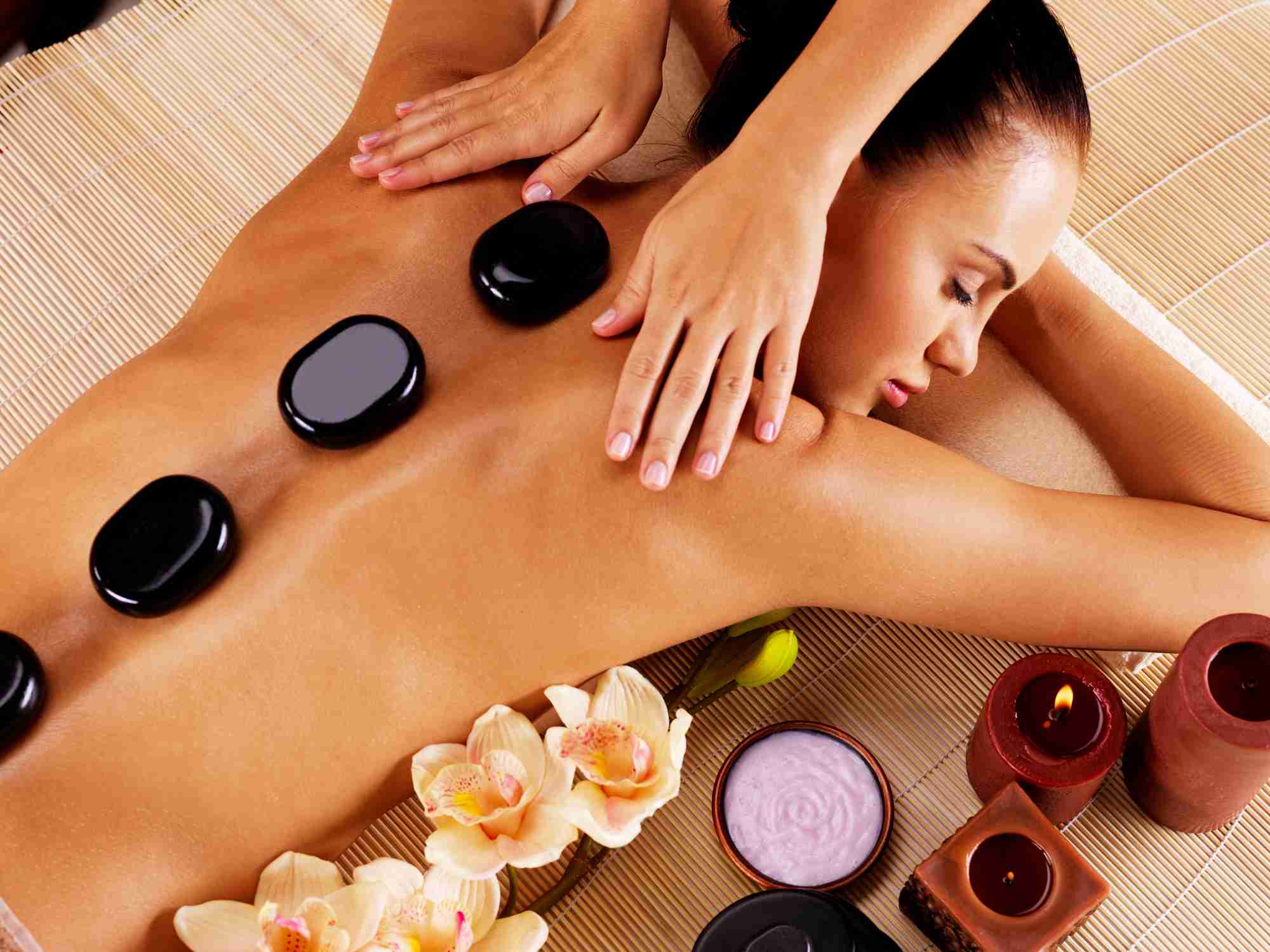 Warm basalt stones arranged along a client's back for hot stone therapy